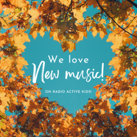 Image description: a photo of orange leaves on trees with the background of a blue sky. There is a gap in the branches in the center of the images that resembles a heart & in the gap are the words, "We love new music! On Radio Active Kids!"